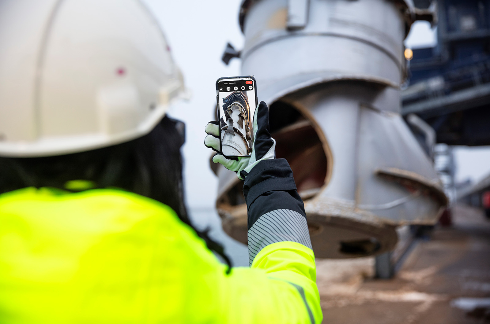 worker taking a mobile photo of a machine