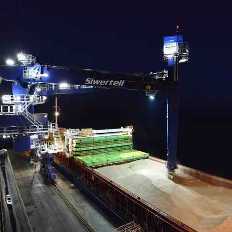 Blue Siwertell Ship unloader in operation at night