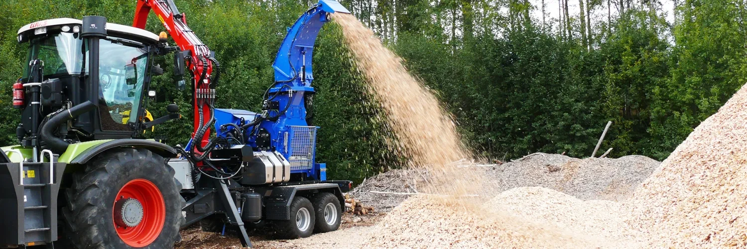 tractor in the woods with a mobile chipper