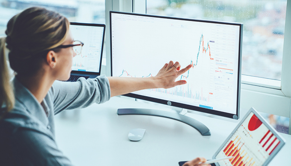 Woman comparing figures on a computer screen