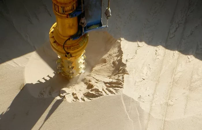 The inlet feeder on a Siwertell ship unloader in a ship hold with fertilizer.