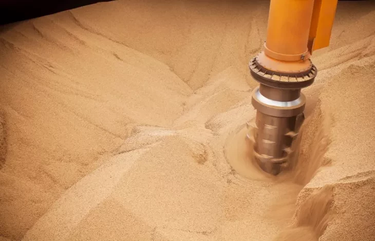 A Siwertell screw type ship unloader in a ship hold filled with grain